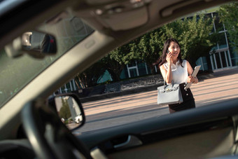 打电话的青年女人走向汽车