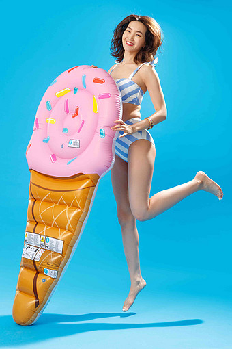 扶冰淇淋形状的浮排跳跃的比基尼美女跳跃高质量照片