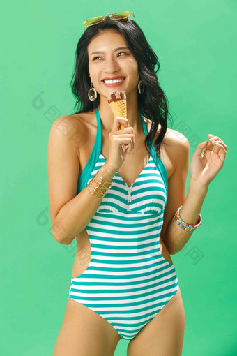 快乐的泳装美女吃冰淇淋享乐高清照片