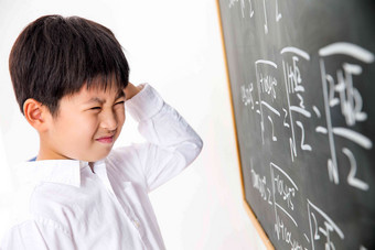 小学男生被数学题难住黑板清晰素材