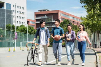 快乐的大学生在校园里步行抱着写实场景