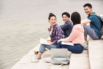 户外大学生坐在台阶上闲聊滑板写实相片
