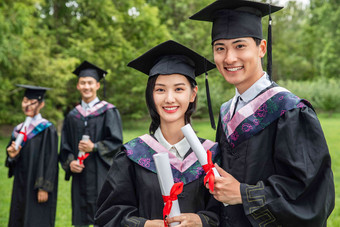 草地上穿着学士服的大学生们幸福写实场景