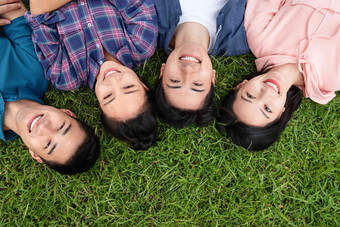 快乐的大学生躺在草地上四个人高端照片