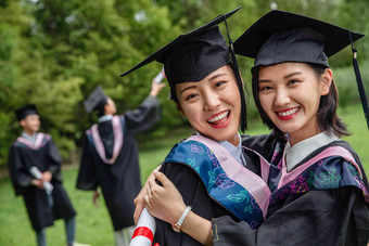 户外穿着<strong>学士</strong>服的大学生拥抱庆祝