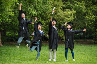 兴奋的大学生穿着学士服庆祝毕业