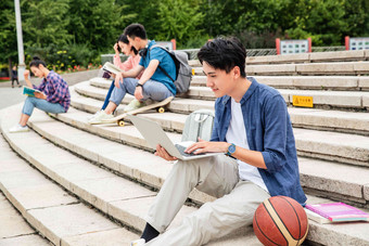 热爱学习的大学生坐在台阶上学习