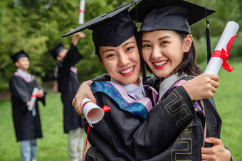 户外穿着学士服的大学生们树写实图片