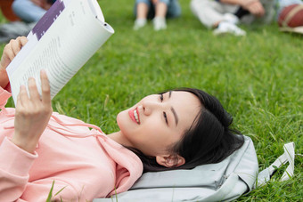 大学生躺在草地上看书学生高端照片