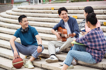年轻的大学生坐在台阶上闲聊