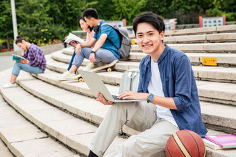 快乐的大学生坐在台阶上学习