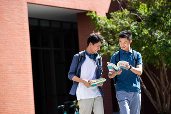 校园里边走路边探讨学习的年轻男子认真氛围素材