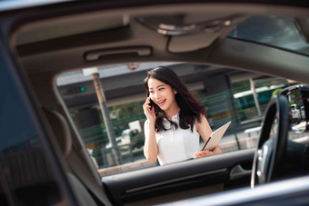 打电话的青年女人走向汽车