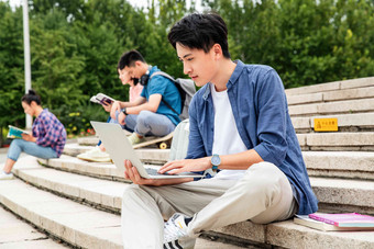 快乐的大学生坐在台阶上学习女人氛围摄影