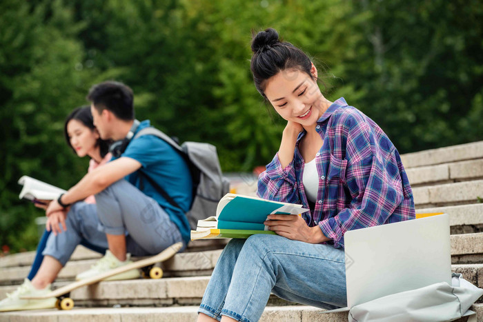 快乐的大学生坐在台阶上学习互联网高质量照片