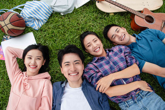 快乐的大学生躺在草地上友谊氛围拍摄