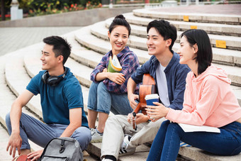 年轻的大学生坐在台阶上闲聊大学高端照片