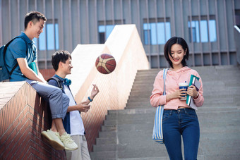 刚下课的大学生在校园里抱着清晰摄影图