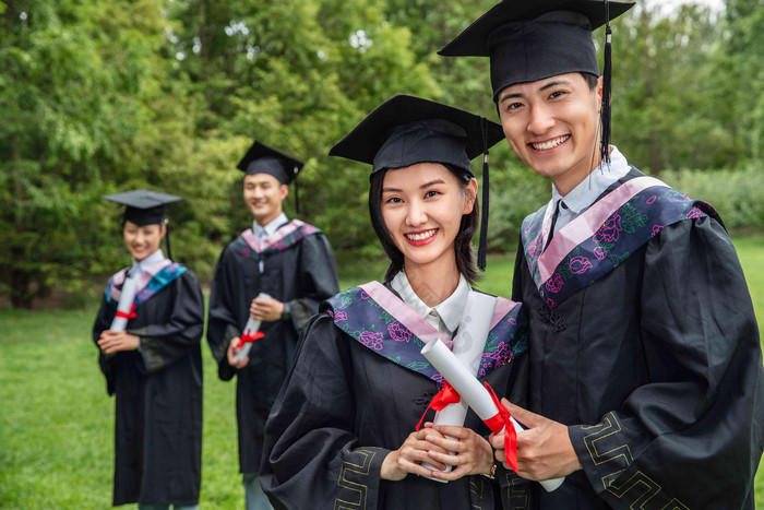 户外穿着学士服的大学生们毕业氛围场景