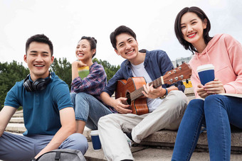 年轻的大学生坐在台阶上弹吉他同学高端场景