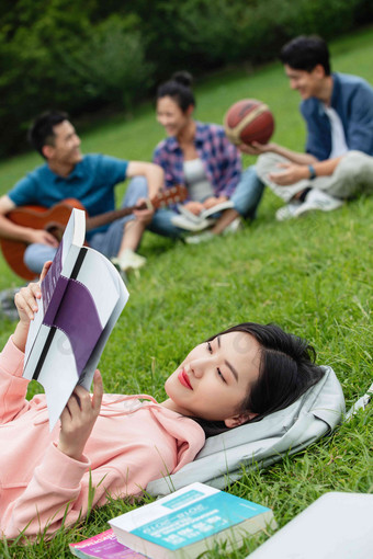 大学生在草地上享受课余时间