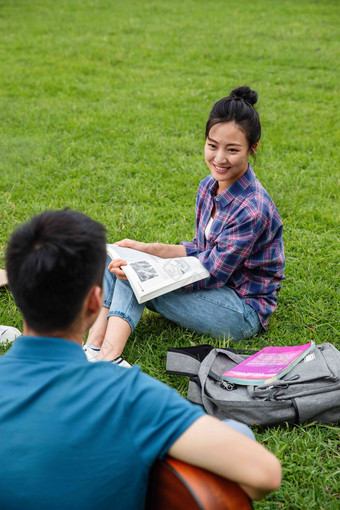 快乐的女生坐在草地上听同学弹吉他