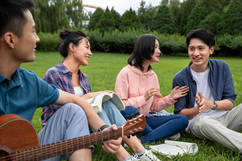快乐的大学生在草地上弹吉他唱歌吉他氛围拍摄