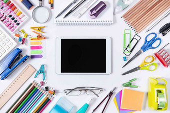 白色桌面上的学习用品和平板电脑彩色铅笔氛围图片