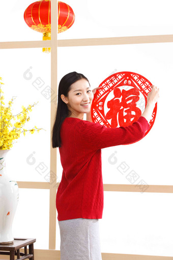 年轻女人新年贴福字<strong>窗花</strong>清晰影相