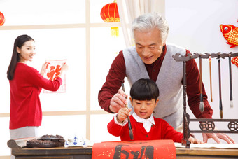 快乐家庭过新年<strong>写春联</strong>毛笔高端图片