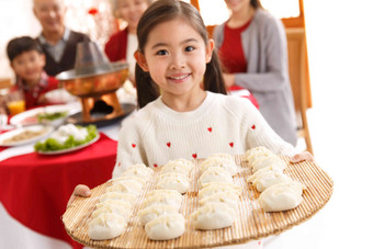 小女孩过年端着饺子庆祝高端影相