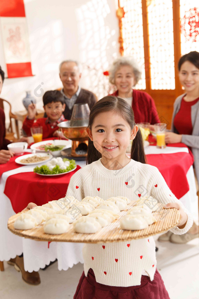 小女孩过年端着饺子火锅高端摄影图