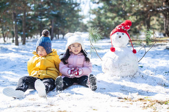 坐在<strong>雪</strong>地上<strong>玩</strong>耍的儿童和<strong><strong>雪</strong>人</strong>