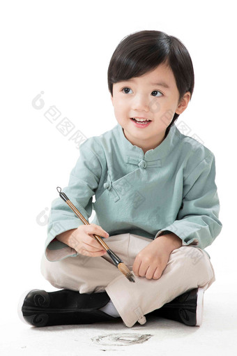 小男孩盘腿坐着拿毛笔写字传统服装影相