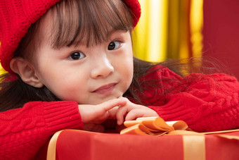 幸福的小女孩趴在礼物包装盒上