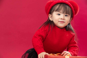 可爱的小女孩拿着新年礼物红色写实相片