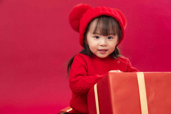 可爱的小女孩趴在新年礼物上礼品盒高清素材