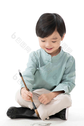 可爱的小男孩坐在地上用毛笔写字留白清晰拍摄