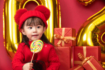 过新年的小女孩吃棒棒糖摄影高质量镜头图片