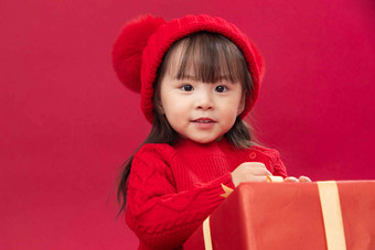 可爱的小女孩拿新年礼物上一个人氛围相片