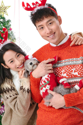 抱着宠物狗的青年情侣过圣诞节相伴氛围摄影图