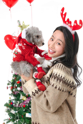 抱着宠物狗的青年女人过圣诞节