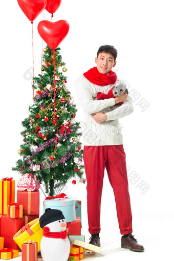 抱着宠物狗的青年男人过圣诞节圣诞装饰物清晰拍摄