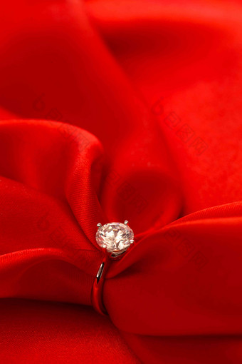 红丝绸和钻石戒指相片