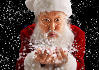 圣诞老人捧着雪在吹白色写实照片
