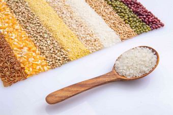 五谷杂粮平铺和盛满大米的木匙米高端照片