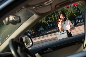 打电话的青年女人走向汽车