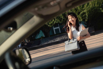 打电话的青年女人走向汽车