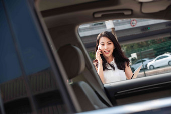 打电话的青年女人走向汽车