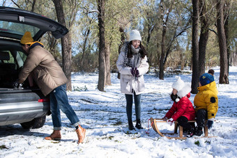 在<strong>雪地</strong>上准备玩雪橇的一家人夫妇氛围拍摄